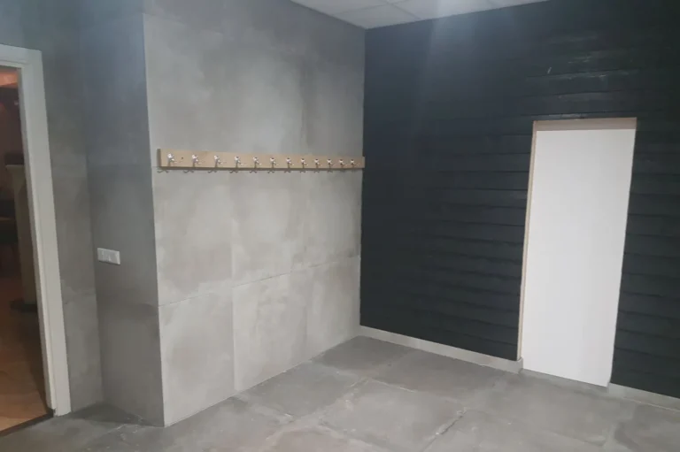 Grijze wandtegels naast een zwarte wand
